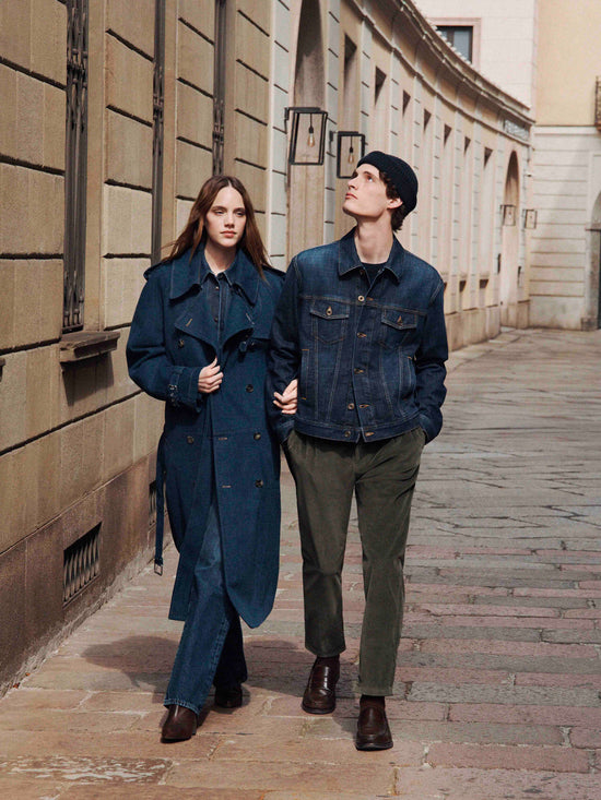 Contemporary street style: couple strolling through historic architecture in coordinated navy and earth-tone outfits