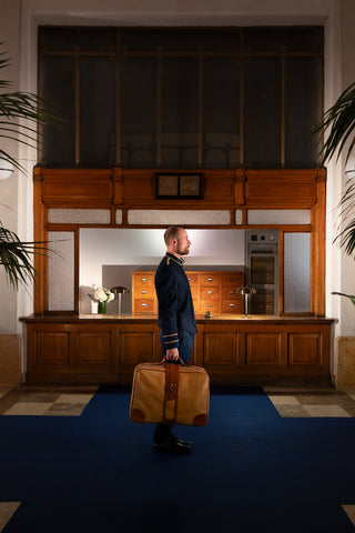 Classic nighttime reception in a vintage five star hotel: a monumental wooden front desk, frosted glass panels, and chrome knobs