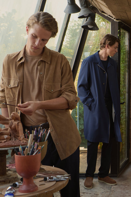 Two men wearing tan suede overshirt and blue coat in creative studio