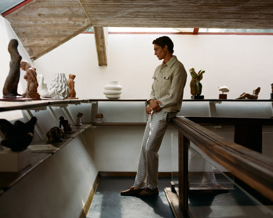 Man wearing beige shirt and checkered trousers in modern interior