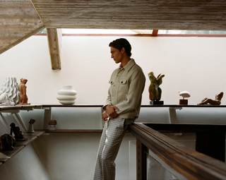 Man wearing beige shirt and checkered trousers in modern interior